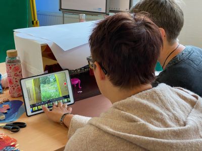 Alice im Trickfilmland: Zwei Menschen mit Tablet